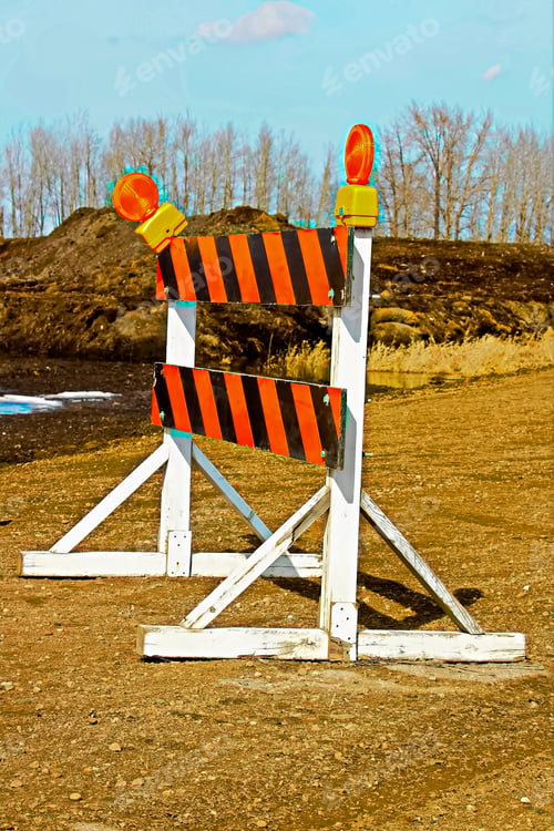 Preview: A construction barricade on a gravel road