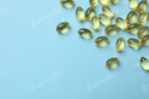Preview: Vitamin capsules on light blue background, top view. Space for text