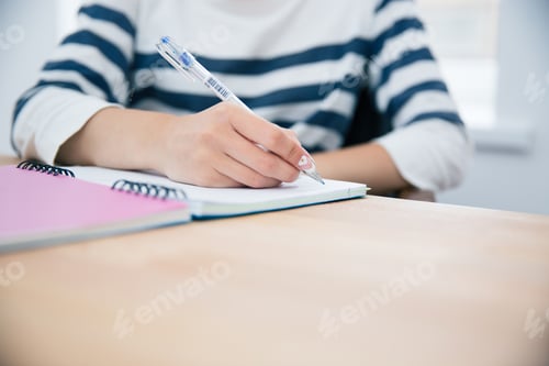 Preview: Closeup Portrait Of A Woman Writing In Notepad At Office