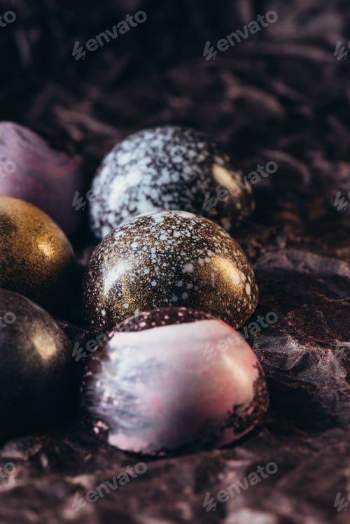 Preview: closeup view of pile of different chocolate candies on crumpled paper