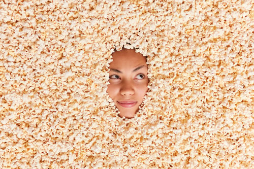 Preview: Serious woman focused away drowned in popcorn while watching movie eats tasty dessert has pensive ex