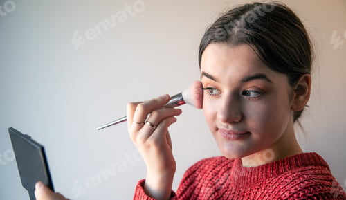Preview: Portrait of a young woman, the process of doing makeup with brushes.