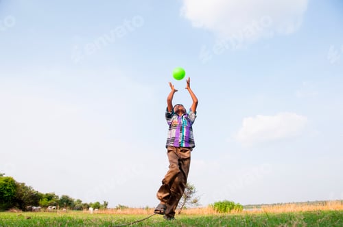 Preview: Indian boy playing with ball on the field