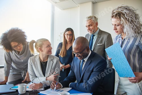 Preview: Focused businesspeople working together at a table in an office