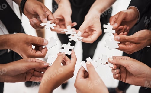 Preview: Closeup shot of a group of unrecognisable businesspeople joining puzzle pieces together