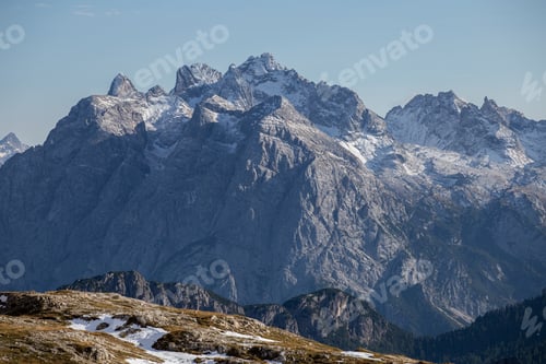 Preview: Breathtaking shot of snowy rocks in the Italian Alps under the bright sky