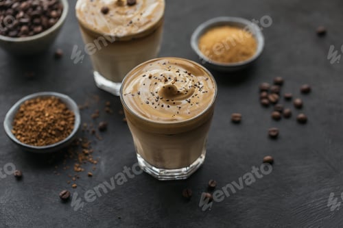 Preview: Glass of Iced Dalgona Coffee, trendy fluffy creamy whipped coffee and milk on black background.