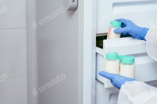 Preview: Hand placing breast milk container in freezer drawer