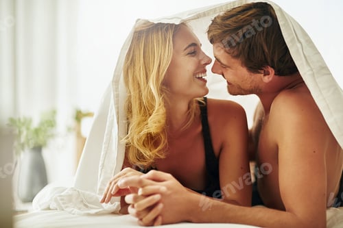 Preview: Shot of a young couple sharing an intimate moment under the covers in bed