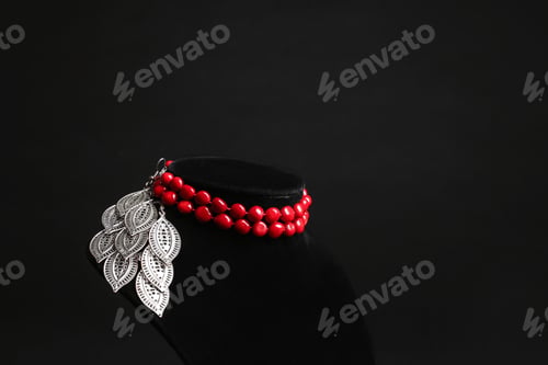 Preview: Stylish jewelry on stand against black background, space for text