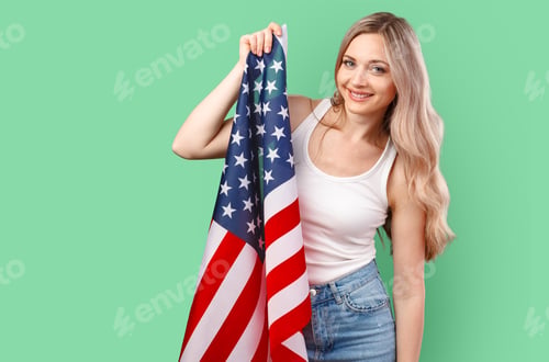 Preview: Portrait of a young woman holding USA flag isolated on color background