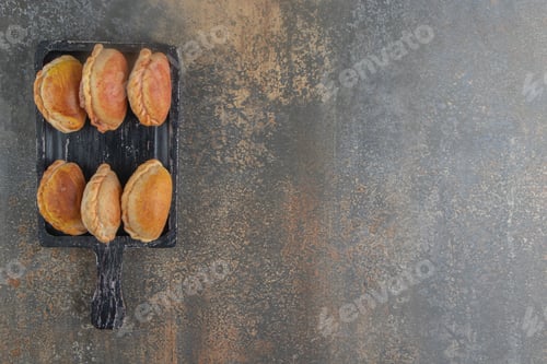 Preview: Bundle of nut filled buns on a black wooden board on wooden/marble background
