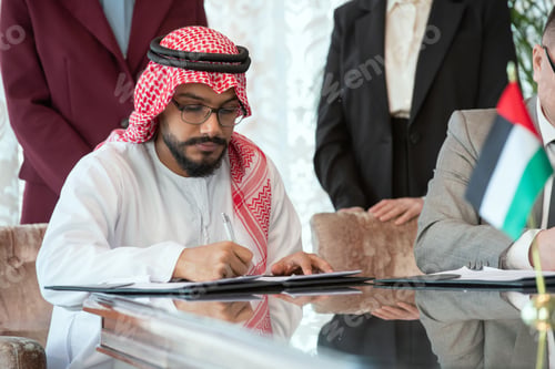 Preview: Confident Arabian businessman or delegate in national clothes signing contract