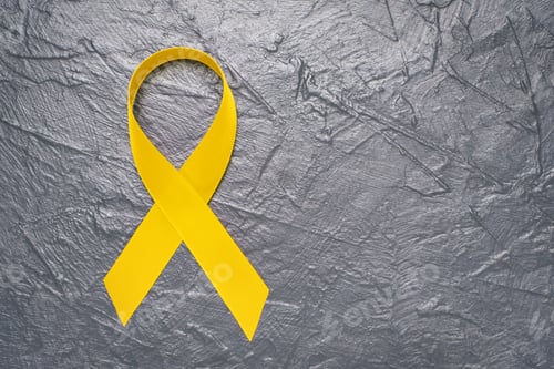 Preview: Yellow ribbon on textured gray background with copy space close-up.