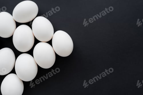 Preview: Top view of organic eggs isolated on black with copy space