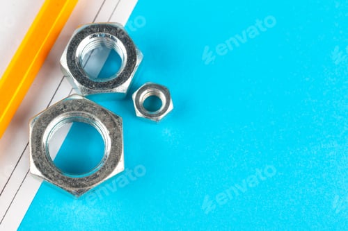 Preview: Blue industry or construction abstract background with various nuts on blue surface