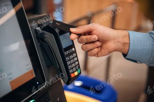 Preview: Close up view of man customer that is paying for products by credit card in grocery store