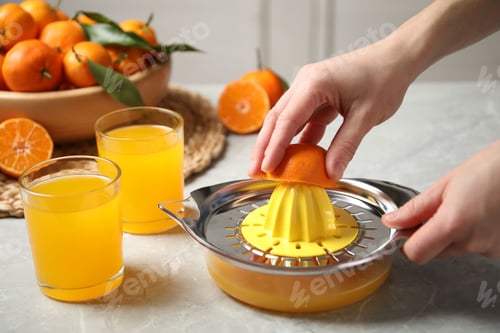 Preview: Woman making fresh tangerine juice indoors, closeup