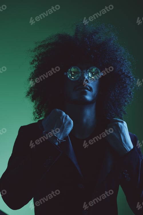 Preview: Fashion portrait of a man with curly hair on a green background with sunglasses, multinational
