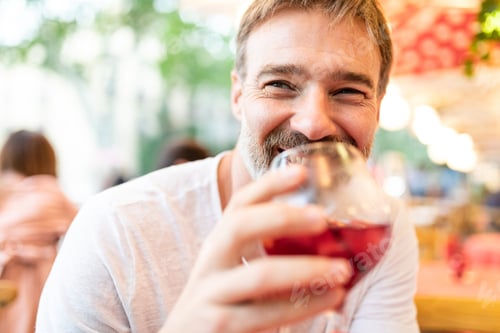 Preview: Joyful man enjoying a glass of wine at a restaurant in Barcelona