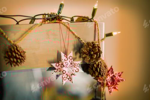 Preview: Christmas decorations. Fairy lights, pine cones and paper stars.
