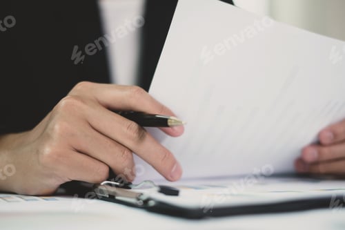 Preview: The businessman hand sits at their desks and calculates financial graphs showing the results