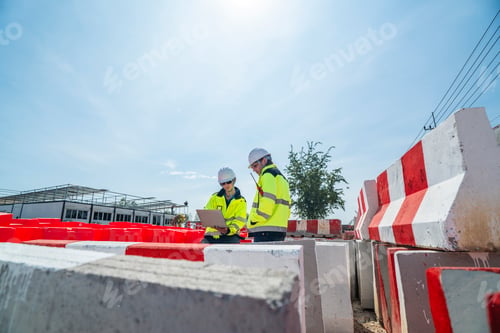 Preview: An engineer in visibility jacket and helmet working on construction site.
