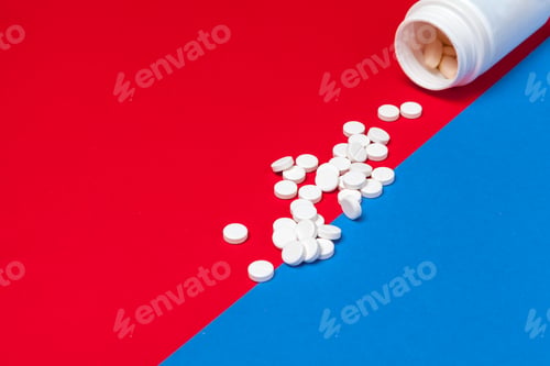 Preview: White medical pills on a two color red and blue background