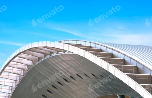 Preview: Curve metal roof of modern building against blue sky background