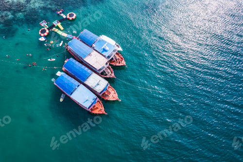 Preview: Traditional ferry anchored and tourist snorkeling and enjoying with coral reef in tropical sea