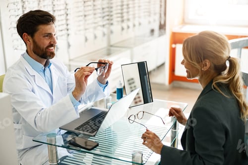 Preview: An ophthalmologist consults a client at his workplace in an optician's shop