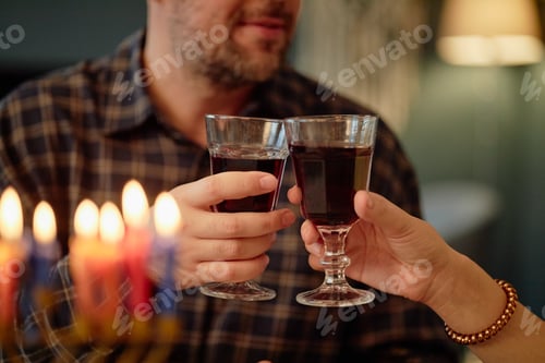 Preview: Middle Aged Caucasian Man Toasting Wine Glasses during Hanukkah Celebration