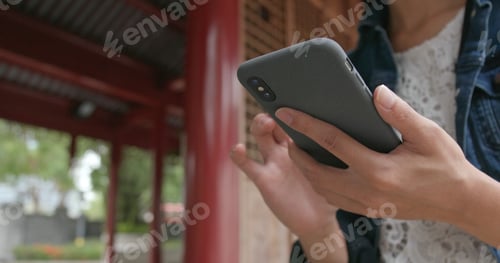 Preview: Close up of woman use of mobile phone in Chinese garden
