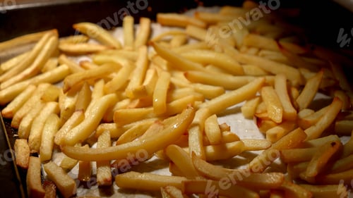 Preview: Closeup of pouring oil on frying french fries in oven. Fast food, healthy nutrition, cooking in oven