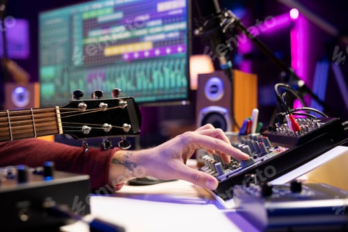 Preview: Sound engineer using mixing console and acoustic guitar in home studio