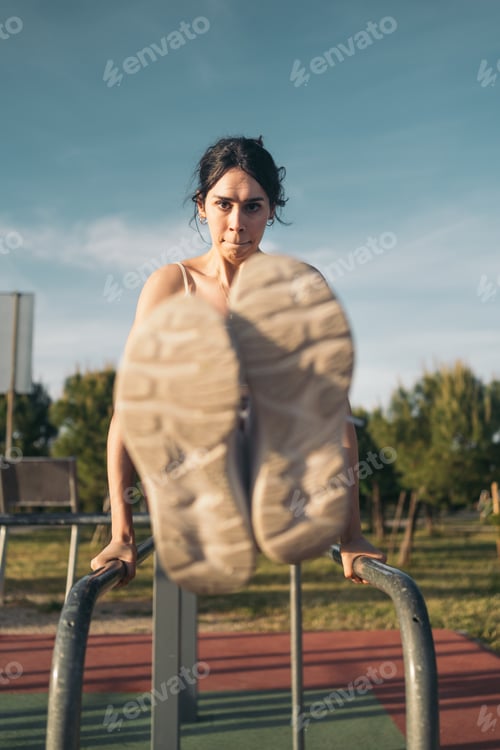 Preview: Calisthenic woman doing L-sits on street workout bars