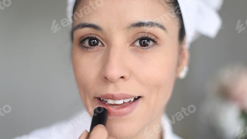Preview: Beautician applying lipstick getting ready for work at the beauty salon