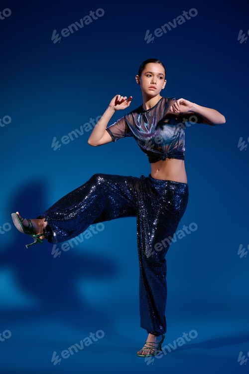 Preview: Stylish young woman showcases modern fashion in dynamic studio setting with vivid colors