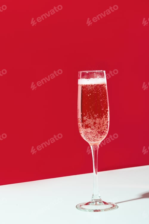 Preview: Wineglass of champagne on red and white. Holiday celebration concept. Christmas holiday.