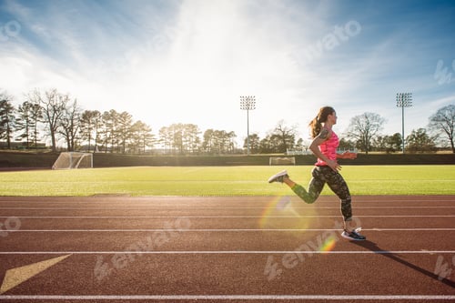 Preview: Young female athlete running on race track
