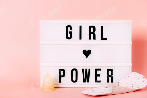 Preview: "girl power" sign with menstrual cup and reusable pad with pink background. Feminism. Zero waste