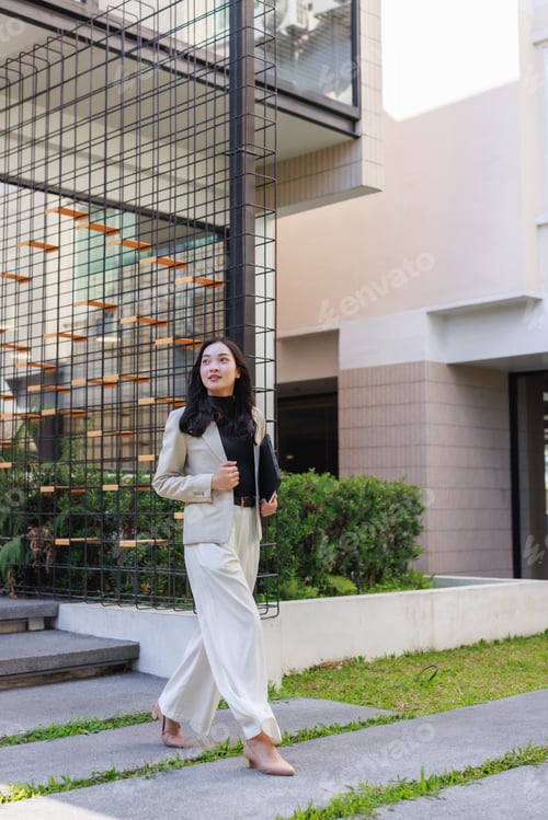 Preview: Young businesswoman walking confidently through modern urban space