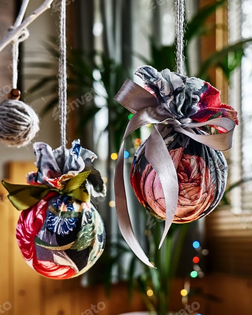 Preview: Handmade fabric christmas balls on the branch on blurred christmas lights background