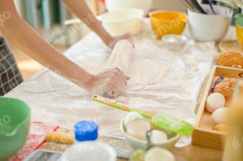 Preview: A young beautiful Asian woman is baking in her kitchen , bakery and coffee shop