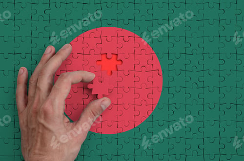 Preview: Bangladesh flag is depicted on a puzzle, which the man's hand completes to fold.