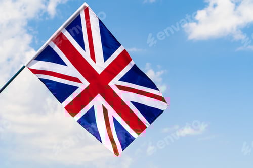 Preview: United Kingdom Flag waving on wind in blue sky
