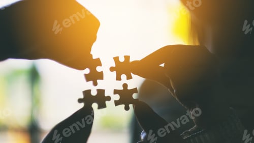 Preview: Silhouette image of many people holding and putting a piece of white jigsaw puzzle together