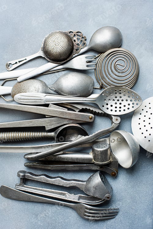 Preview: Assortment of vintage kitchen utensils on a textured grey surface