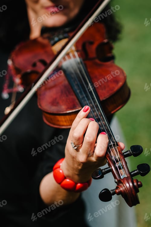 Preview: Violin player hands. Violinist playing violin on background of field. Performance on nature. Close