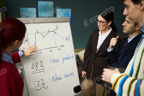 Preview: Young Adult Woman Explaining Sales Chart to Diverse Colleagues